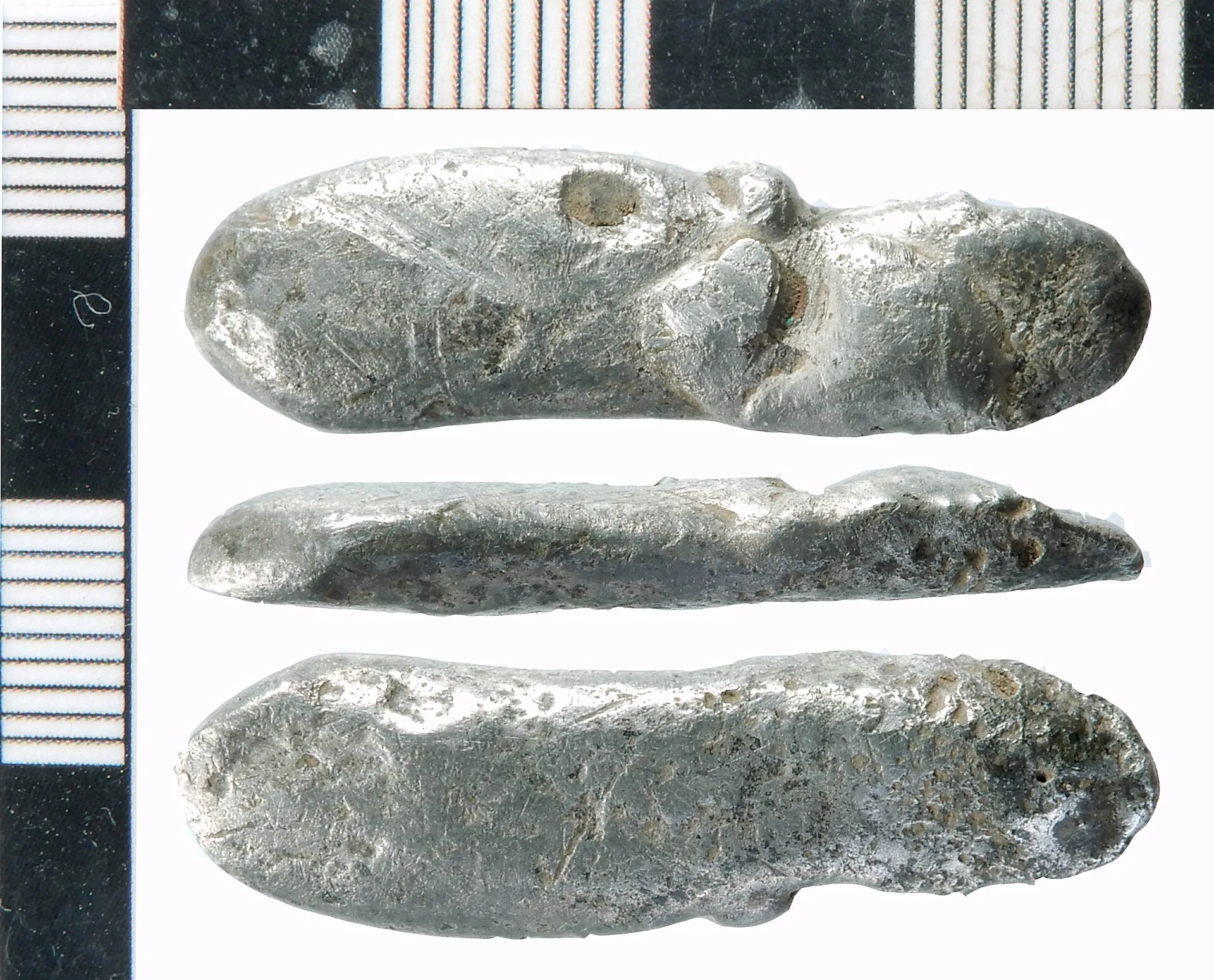 Silver possible ingot. Cast bar of oval section with rounded ends, with one flat surface suggesting it has solidified on a flat smooth surface; the opposite long side may have been lightly hammered. The form may commend an identification as a silver ingot, but, in the absence of clear hammering mark. How to document a non-destructive bullion examination