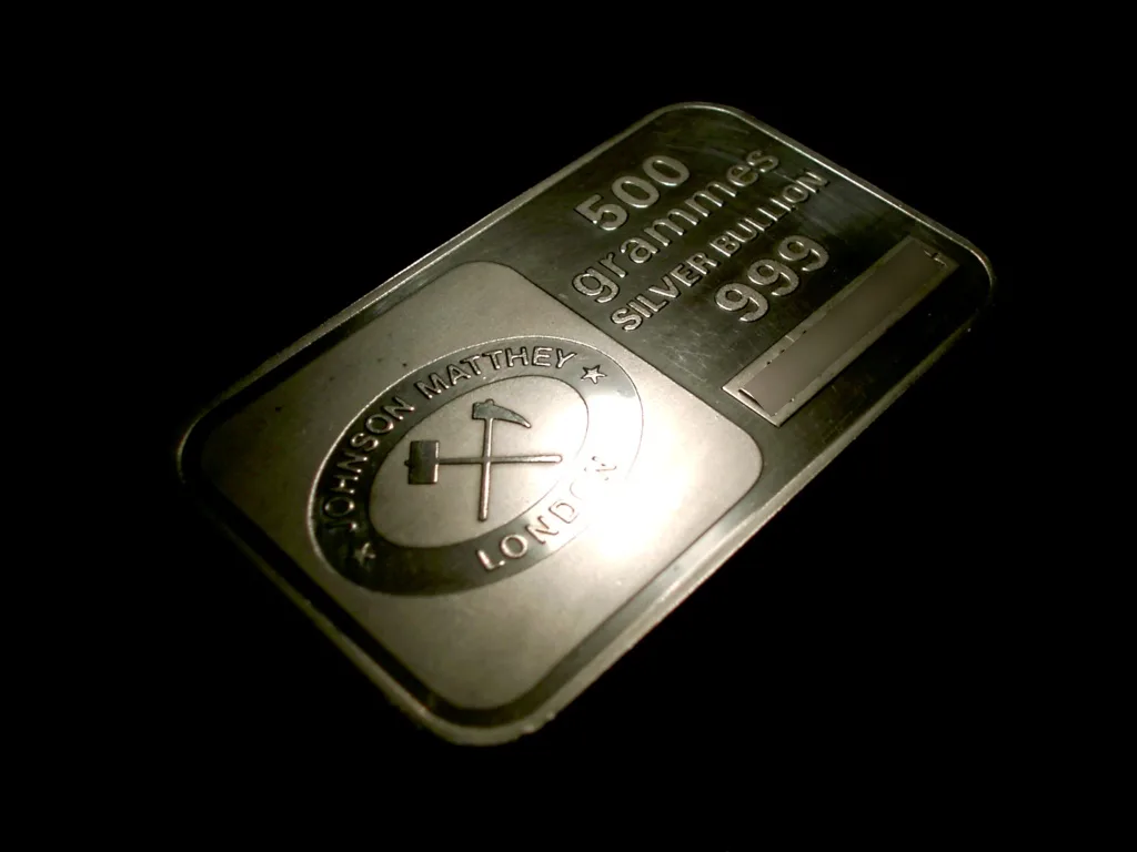 500 g en:silver bullion bar produced by en:Johnson Matthey . The serial number (lower right side of bar) has been obscured. Picture taken and released into the public domain by en:User:Kallemax. Silver toning, milk spots, weight, and packaging problems