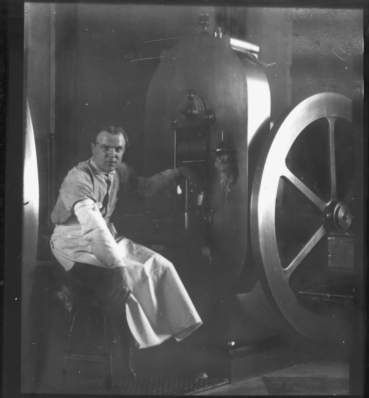 A San Francisco Mint press operator beside a coin press